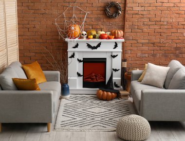 Cadılar Bayramı için şömine ve kanepelerle dekore edilmiş oturma odasının içi.