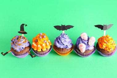 Yeşil arka planda leziz Cadılar Bayramı kekleri