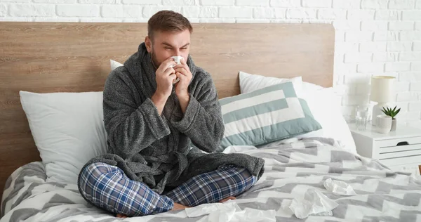 ベッドに座ってインフルエンザの男性 — ストック写真
