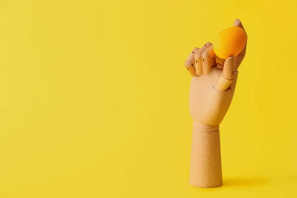 黄色の背景にイースターエッグと木製の手 — ストック写真
