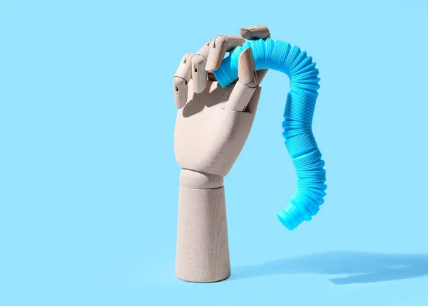 Mão Madeira Com Pop Tube Fundo Azul — Fotografia de Stock