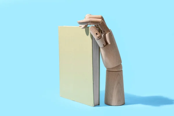 Mão Madeira Com Livro Sobre Fundo Azul — Fotografia de Stock