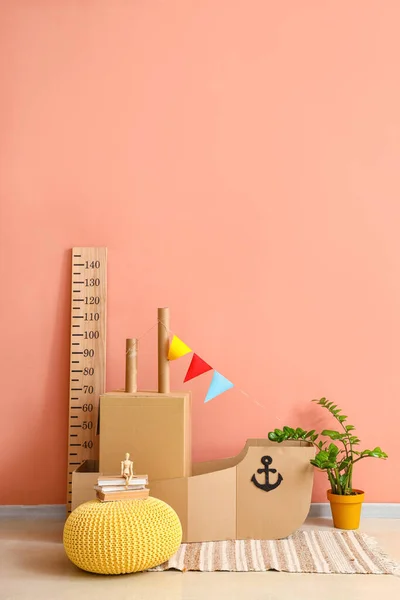 粉红墙壁附近装有玩具纸船的儿童房内 — 图库照片