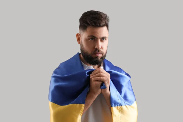 Młody Człowiek Flagą Ukrainy Modlący Się Szarym Tle — Zdjęcie stockowe