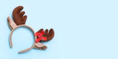 Açık mavi zemin üzerinde güzel Noel geyiği boynuzları ve metin için boşluk