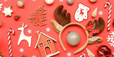 Kırmızı arka planda Noel geyiği boynuzları ve güzel dekoru olan kompozisyon