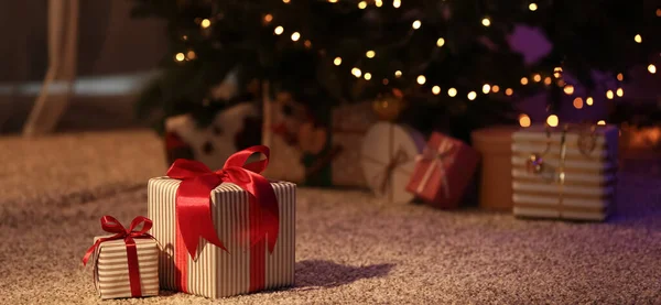 部屋のモミの木の近くの床の上に美しいクリスマスプレゼント — ストック写真
