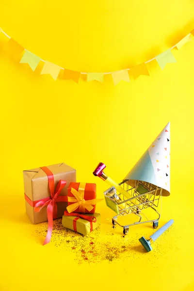 Birthday composition with shopping cart and gift boxes