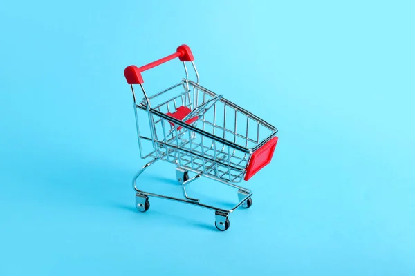 色の背景に赤いショッピングカート — ストック写真