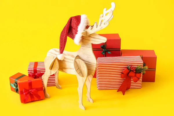 Wooden Reindeer Santa Hat Christmas Presents Yellow Background — Stock Photo, Image