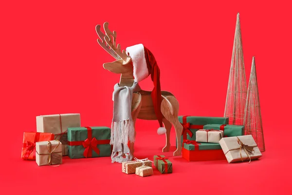 红底木制驯鹿 头戴圣诞帽 头戴圣诞礼物 — 图库照片