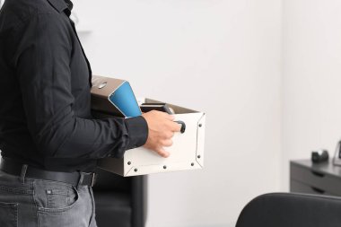 Ofisinde kişisel eşyalarıyla birlikte kovulan genç adam.