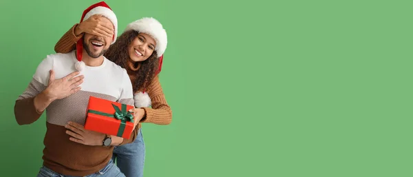 Młoda Kobieta Daje Prezent Świąteczny Mężowi Zielonym Tle Miejscem Tekst — Zdjęcie stockowe
