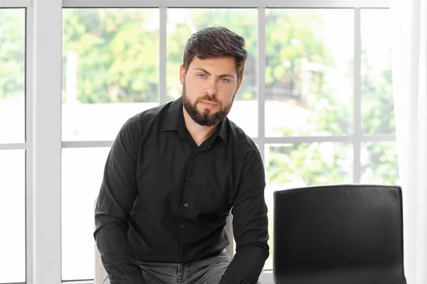 Fired young man sitting in office