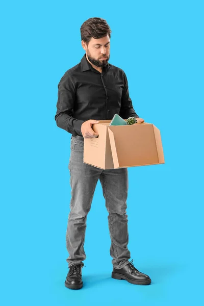 Mavi Arka Planda Ofis Eşyalarıyla Dolu Kutuyu Tutan Kovulmuş Genç — Stok fotoğraf