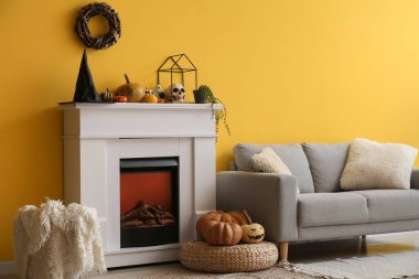 Cadılar Bayramı için şömine ve kanepeyle dekore edilmiş oturma odasının içi.