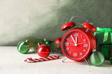 Kırmızı yeni yıl saati ve arkaplanda Noel topları