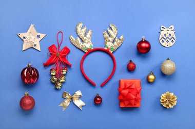 Mavi arka planda hediye ve dekorla Noel geyiği boynuzları