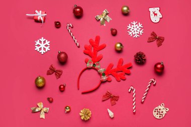 Kırmızı arka planda dekoru olan Noel geyiği boynuzları