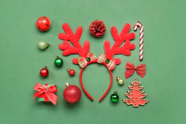 Yeşil arka planda hediye ve dekorla Noel geyiği boynuzları