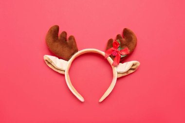Kırmızı arka planda Noel geyiği boynuzları