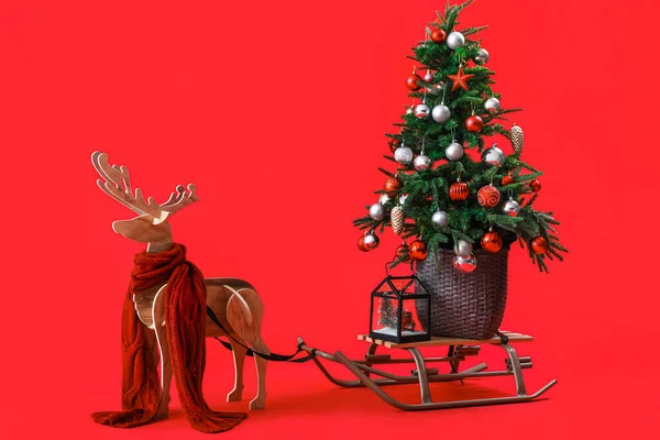 Houten Rendieren Met Sjaal Slee Kerstboom Rode Achtergrond — Stockfoto