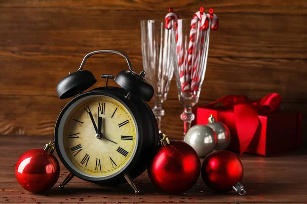 木製の背景に黒い目覚まし時計とクリスマスボール — ストック写真
