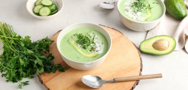 Yeşil gazpacho tabakları ve hafif arka planda malzemeler.