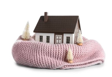 Beyaz arka planda pembe eşarplı ve dekoratif köknar ağaçlı ev modeli. Isıtma kavramı