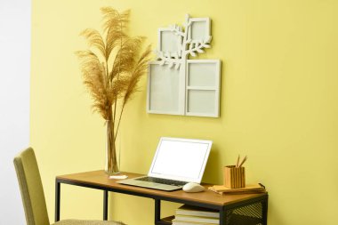 Dizüstü bilgisayarı ve aile ağacı fotoğraf çerçevesi olan modern işyerinin rahat iç mekanı