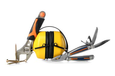 Beyaz arka planda işitme koruyucuları, ingiliz anahtarı, tırnak ve kerpeten