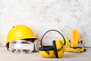 İşitme koruyucuları hafif arka planda inşaatçı araçları ile