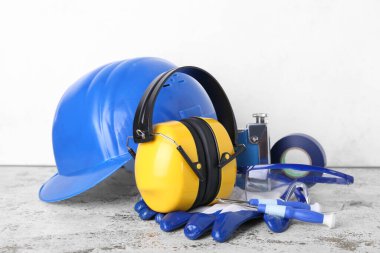 Işık duvarının yanındaki masada inşaatçı aletleri olan işitme koruyucular var.