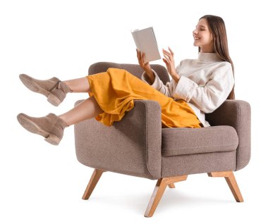 Güzel kadın beyaz arka planda koltukta kitap okuyor.