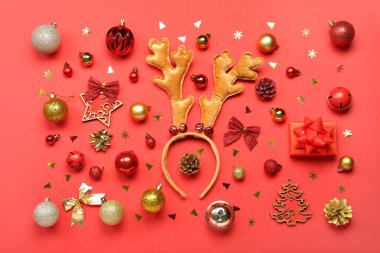 Kırmızı arka planda ren geyiği boynuzları olan güzel bir Noel dekoru.