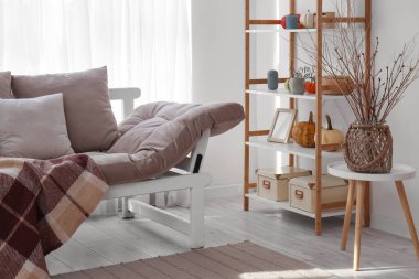 İçinde kanepe, Cadılar Bayramı balkabağı ve raf ünitesi olan bir oturma odası.