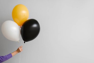 Gri arka planda Cadılar Bayramı balonları olan kadın.