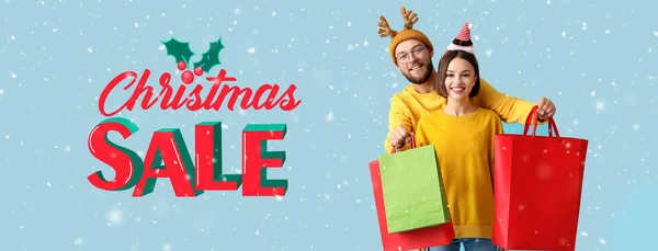 Ευτυχισμένο Νεαρό Ζευγάρι Τσάντες Για Ψώνια Γαλάζιο Φόντο Χριστουγεννιάτικη Πώληση — Φωτογραφία Αρχείου