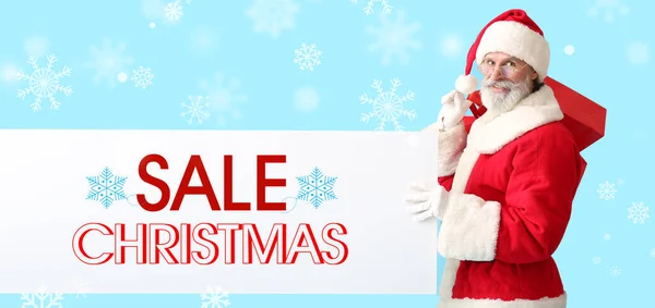 Weihnachtsmann Mit Poster Und Einkaufstaschen Auf Hellblauem Hintergrund Weihnachtsgeschäft — Stockfoto