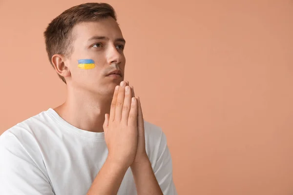 Young Man Drawn Flag Ukraine Praying Beige Background — Stock Photo, Image