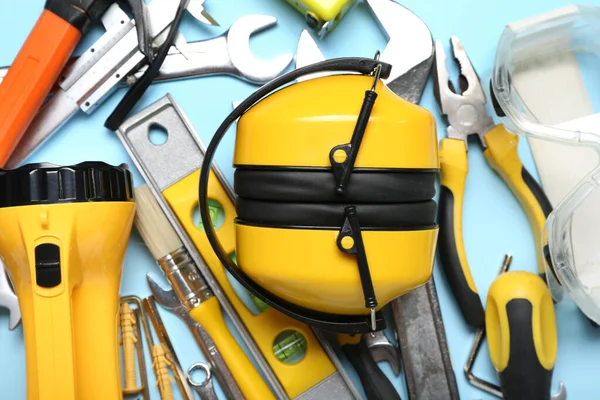 Hearing protectors with builder's tools on blue background