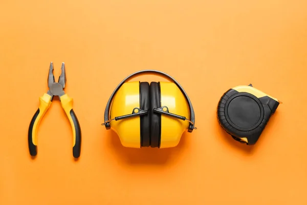 建筑工具和彩色背景的听觉保护器 — 图库照片