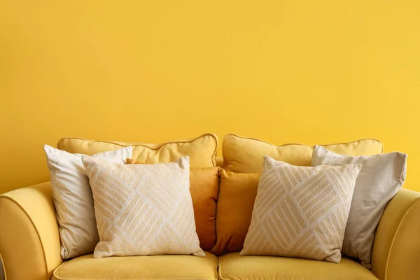 リビングルームのカラーウォールの近くにクッション付きの黄色のソファ — ストック写真