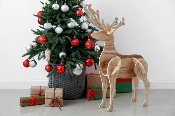 木のトナカイとクリスマスツリーと光の壁の近くのプレゼント — ストック写真