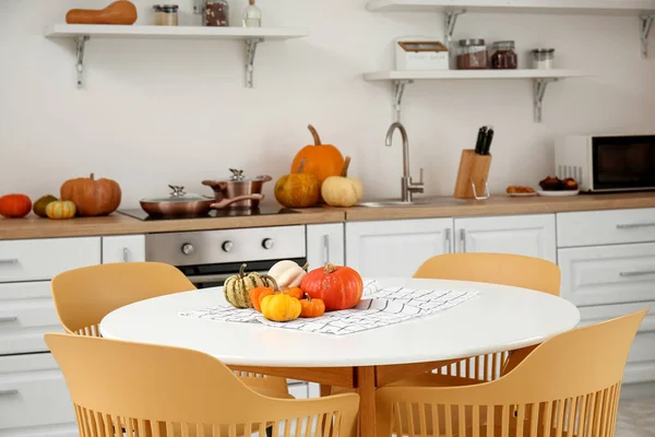 Halloween pumpkins on dining table in light kitchen