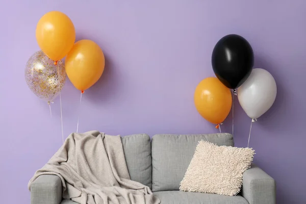 在紫墙附近放有万圣节气球的沙发 — 图库照片