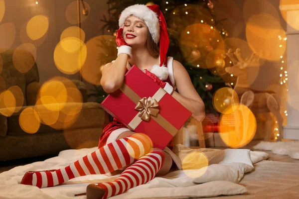 穿着圣诞老人服装 家里还带着圣诞礼物的性感年轻女人 — 图库照片
