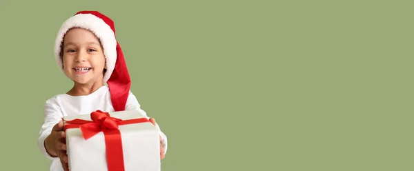 サンタの帽子のかわいい男の子とテキストのためのスペースと色の背景の贈り物 — ストック写真
