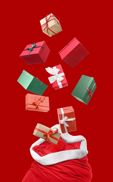 Santa Tasche Und Fliegende Geschenkboxen Auf Rotem Hintergrund — Stockfoto
