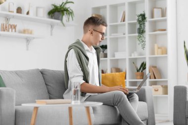 Evde dizüstü bilgisayarlı video sohbeti yapan erkek psikolog.